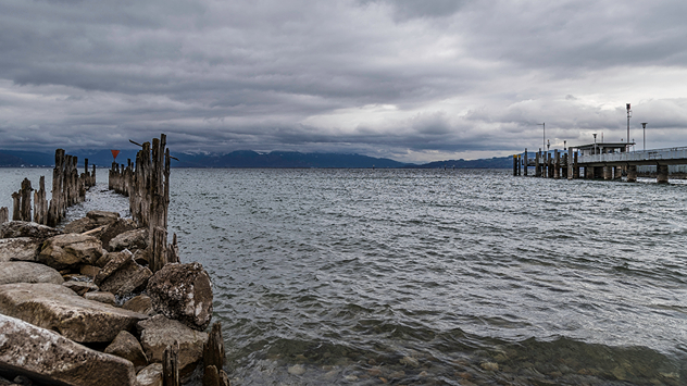 Buhne und Steg am Bodensee bei düsterem Wetter.