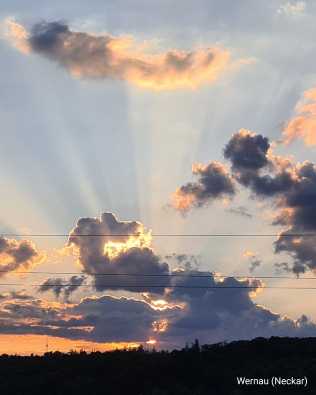 Sonnenuntergang mit dunklen Wolken und markanten Sonnenstrahlen, die fächerförmig über den Himmel reichen. Aufnahme aus Wernau am Neckar.