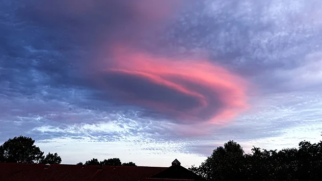 Rosafarben angestrahlte Linsenwolke über Gebäuden in Deidesheim, Rheinland-Pfalz.