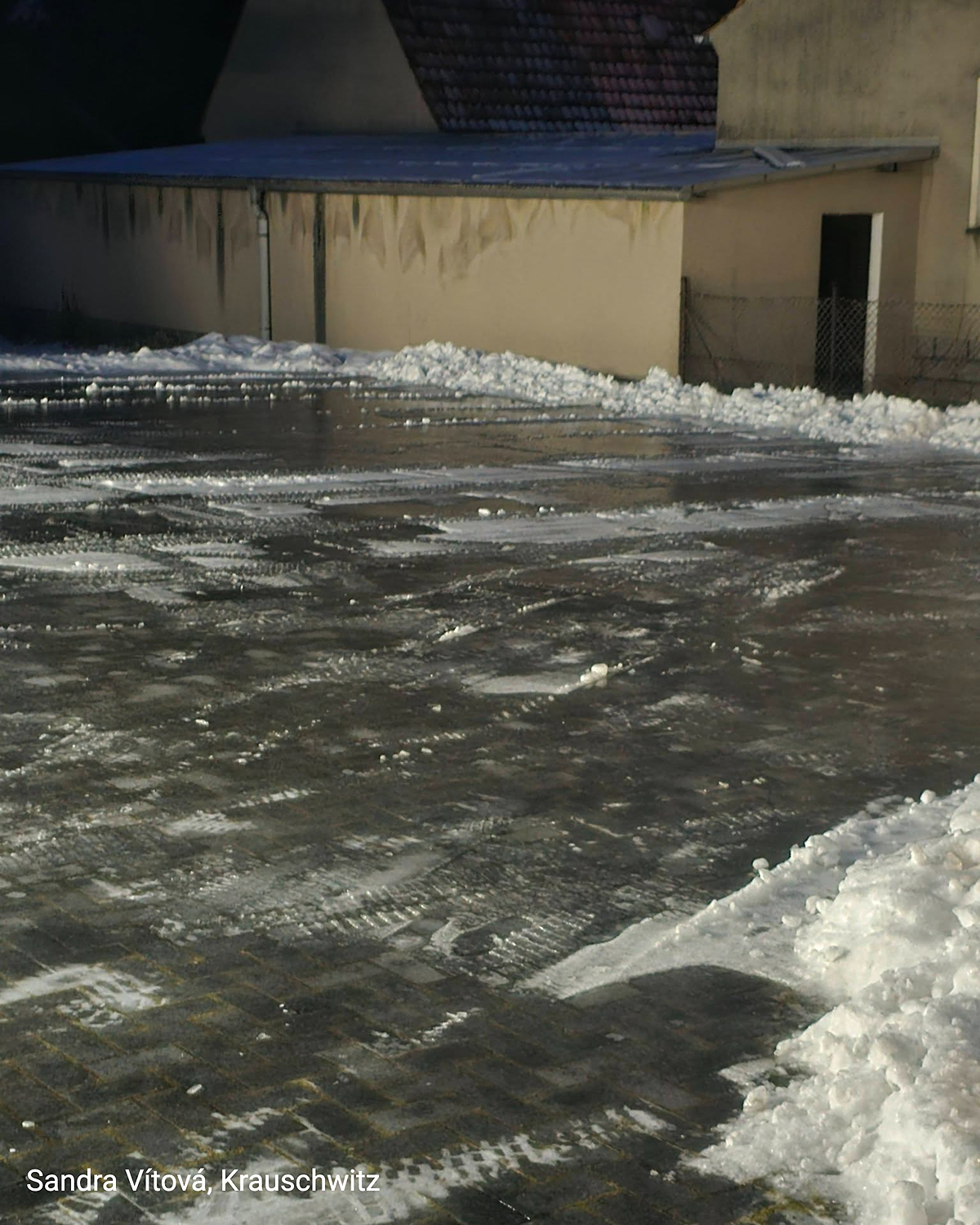 Schmale Straße mit geschlossener Eisschicht, kaum erkennbare Fahrbahnstruktur.