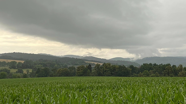 Dunkle Schauerwolke über Bergland - 