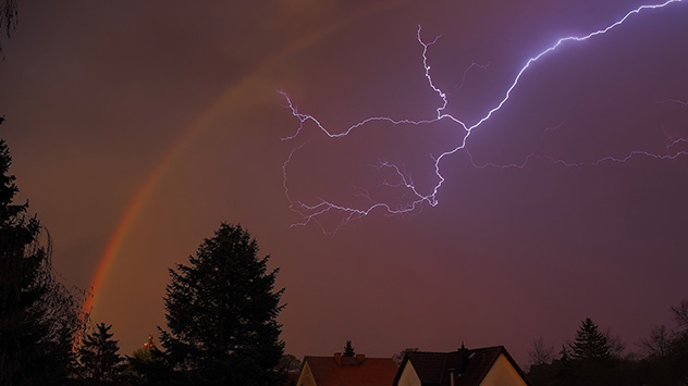 Ein Schnappschuss mit Seltenheitswert: In Bergfelde nördlich von Berlin blitzt es am Himmel und ein Regenbogen hat sich aufgespannt. 
