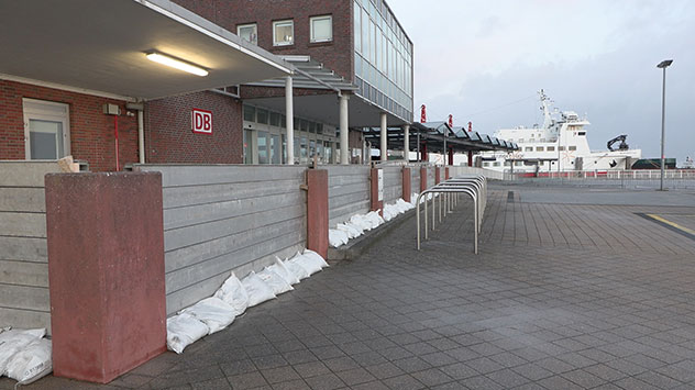Sandsäcke schützen das Terminal des Fährhafens. Der Fährverkehr von und zur Insel Wangerooge bleibt für den gesamten Tag eingestellt.