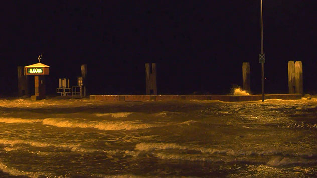 Wellen peitschen im Fährhafen von Norddeich an den Anleger.