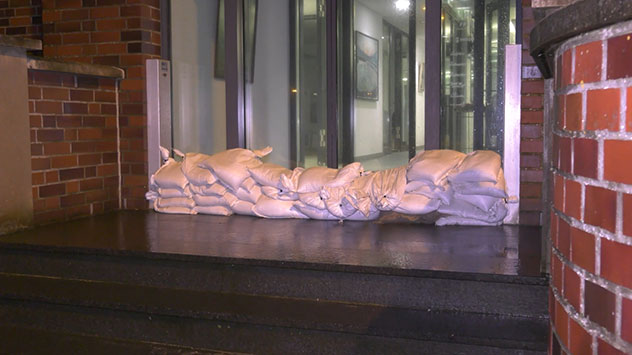 Sandsäcke an den Eingängen sollen verhindern, dass die Wassermassen in die Gebäude eindringen.