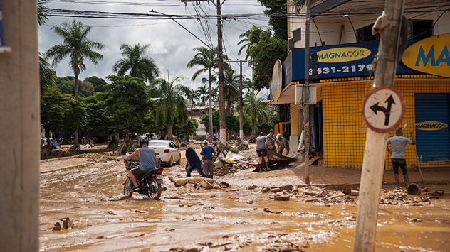 La photo montre des rues inondées d'eau et de boue dans une ville du Brésil.
