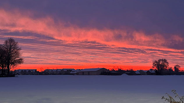 Glühender Himmel über schneebedecktem Feld