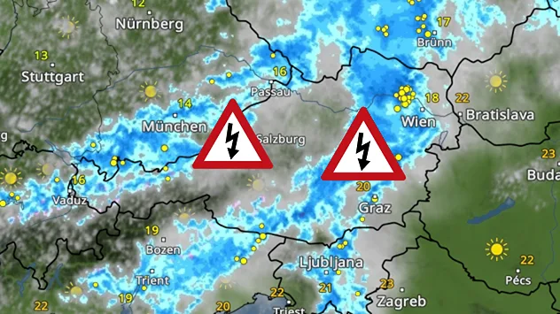 Wetterkarte von Bayern und Österreich mit einem breiten Regen- und Gewitterband; zwei Warnsymbole mit Blitz markieren starke Gewitter bei Salzburg und nahe Graz.