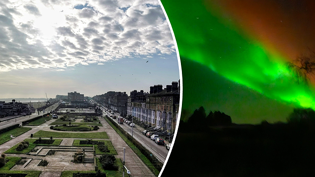 Split image showing a sunlit coastal town seafront with a formal park, terraced buildings, traffic, and broken cloud on the left, and a vivid green aurora glowing over a dark landscape at night on the right, divided by a curved white line.
