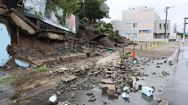 Mud and debris lie on a road after a landslide.