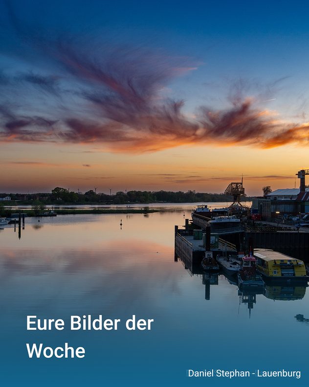 Hafenanlage an der Elbe bei Sonnenuntergang mit farbigen Wolken und Spiegelungen im ruhigen Wasser.