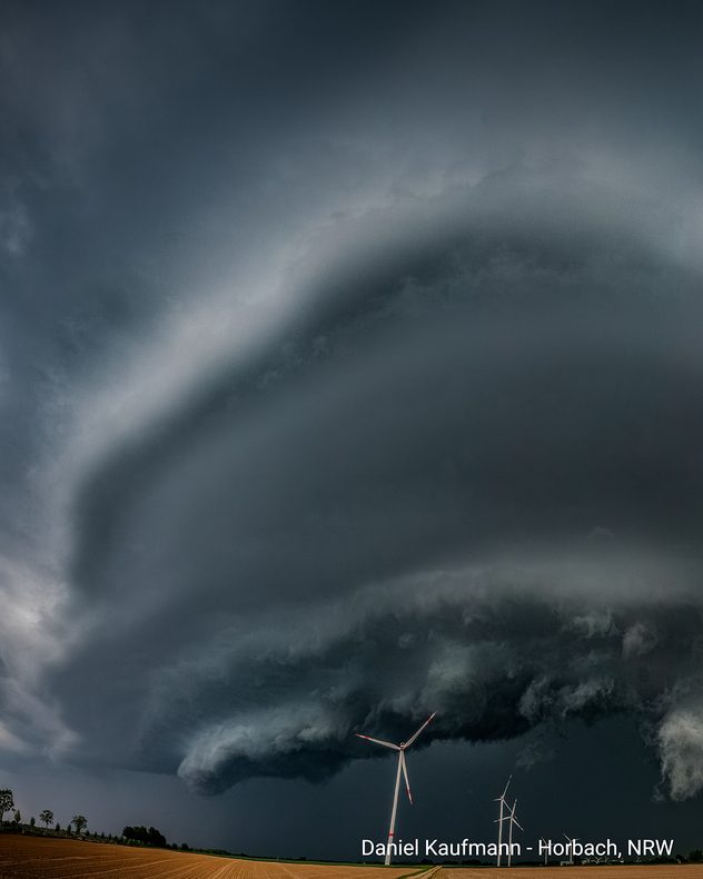 Gewaltige dunkle Gewitterwolke über Feldern und Windrädern bei Horbach in Nordrhein-Westfalen.