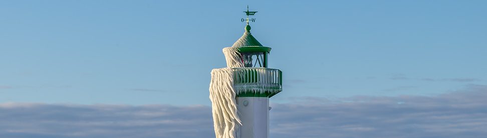 Vereister Leuchtturm an der Küste mit dicken Eisschichten. Klarer Himmel und winterliche Kälte. (c) Klaus Haase