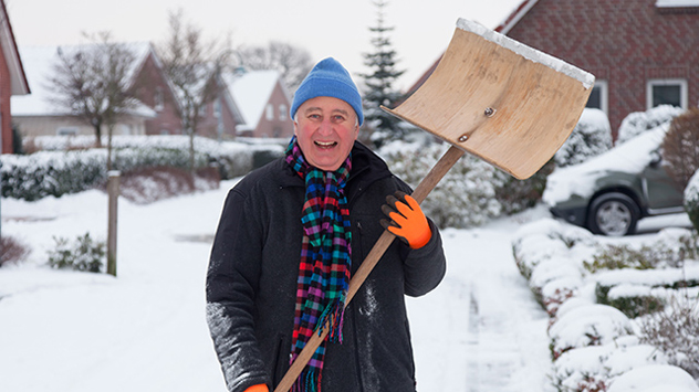 Frau beim Schneeschaufeln