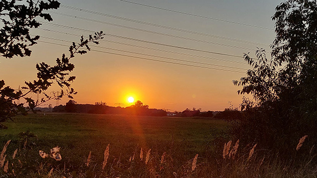Sonne geht in Trebbin über einem Feld unter