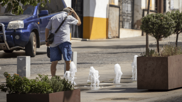 Un hombre se refresca en una fuente de las calles de Mérida.
