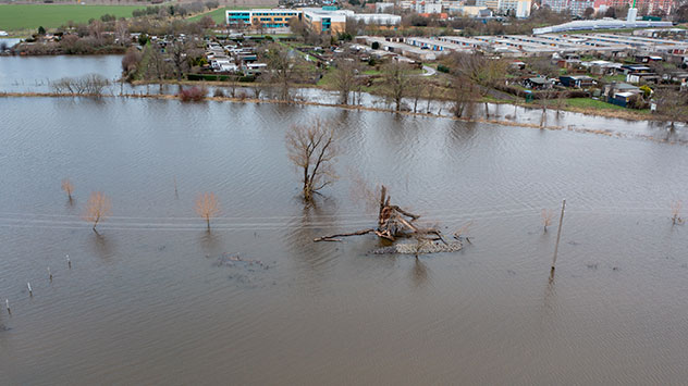 Am Ortsrand von Wolmirstedt im Landkreis Börde stehen Strommasten im Wasser. 