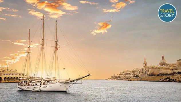 Ein Segelschiff vor der Küste Maltas bei Sonnenuntergang.