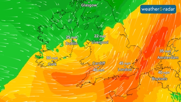 Wind map of the UK, Ireland, and nearby Europe showing stronger gusts in southern areas. London is marked with 45 mph, Cardiff 40 mph, and Cork 30 mph, while Dublin and Liverpool show lighter winds at 25 mph and 22 mph. The background colours shift from green in the north to orange and red in the south, highlighting the strongest winds over southern England and the Low Countries.