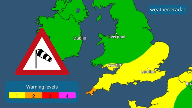 Weather warning map highlighting wind alerts: southern England and south Wales are shaded yellow for level 1 warnings, while a small coastal area in the far south-west is shaded orange for level 2 warnings. A wind hazard warning symbol is displayed on the left.
