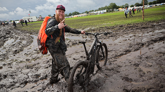 Dieser Metal-Fan ist mit seinem E-Mountainbike auf dem schlammigen Festivalgelände unterwegs.