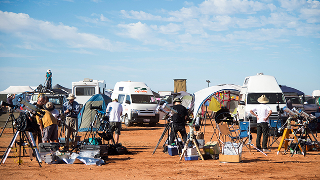 Hobbyastronomen versammeln sich mit optischen Geräten an einem Beobachtungsort