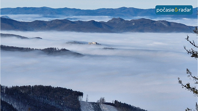 Pohľad na hmlu v pohorí Malá Fatra zhora. V pozadí vyčnieva hrad Lietava.
