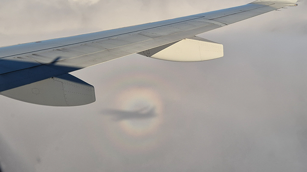 Ein bunter Ringe um den Schatten eines Flugzeuges.