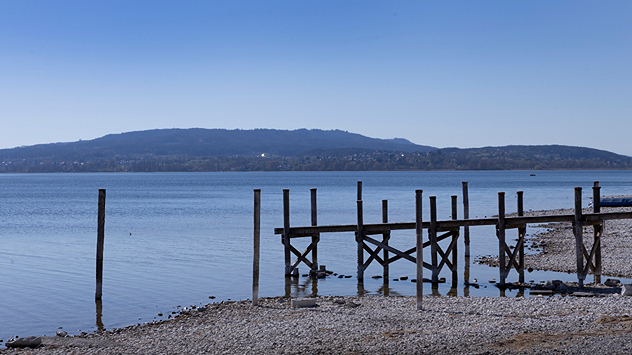 Bodensee mit niedrigem Wasserstand, freiliegendem Ufer und Holzsteg.