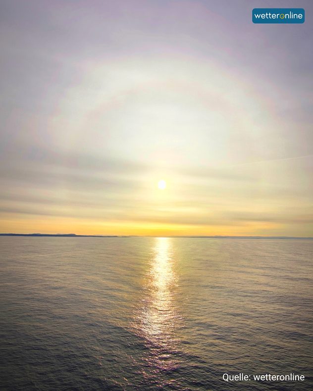 Heller Halo-Kreis rund um die Sonne über der Nordsee am Morgenhimmel.
