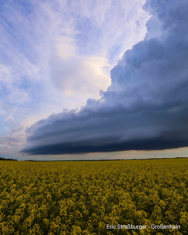 Dunkle Gewitterwolken ziehen über ein Feld bei Großenhain unter dramatischem Abendhimmel.