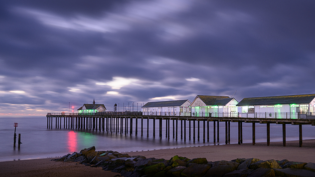 Long-exposure picture of pier with dark clouds overhead.
