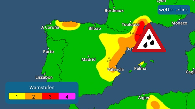 Warnkarte der Iberischen Halbinsel mit farblich markierten Warnstufen. Große Teile Spaniens sind grün dargestellt, während sich von Valencia über Barcelona bis in den Raum Toulouse ein gelb-orange-rotes Band erstreckt. Im Nordosten bei Barcelona ist die höchste Warnstufe in Rot markiert. Ein rotes Warndreieck mit Regentropfen weist zusätzlich auf Starkregen hin. Unten links ist eine Legende mit den Warnstufen 1 bis 4 eingeblendet, rechts oben das Logo „wetteronline“.