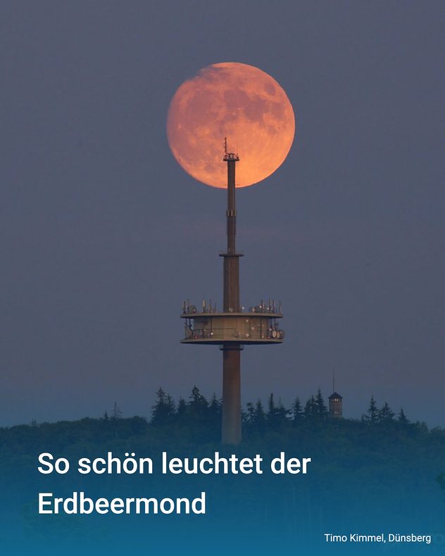 Orangefarbener Erdbeermond hinter dem Fernmeldeturm auf dem Dünsberg bei Gießen am Abendhimmel.
