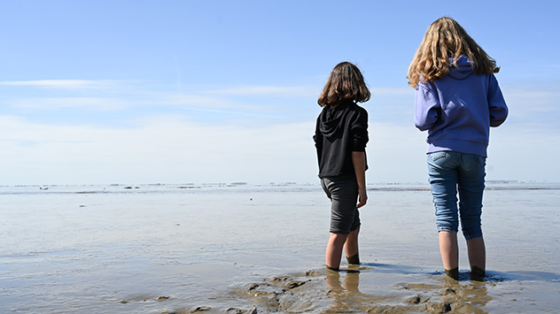 Zwei Mädchen stehen Barfuß im Wattenmeer