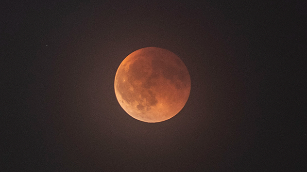 Roter Mond während einer Finsternis über Italien. Die Struktur der Mondoberfläche ist im Schatten sichtbar.