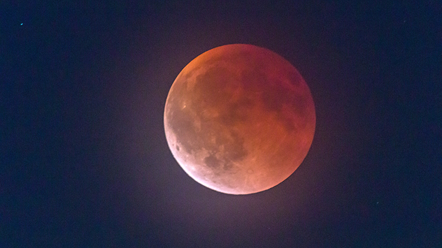 Roter Mond während einer Finsternis über München. Die Strukturen der Oberfläche erscheinen im Schattenspiel.