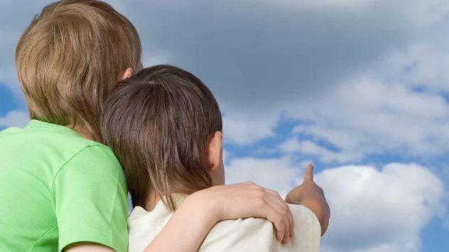 Kinder schauen zum Himmel und beobachten Wolken