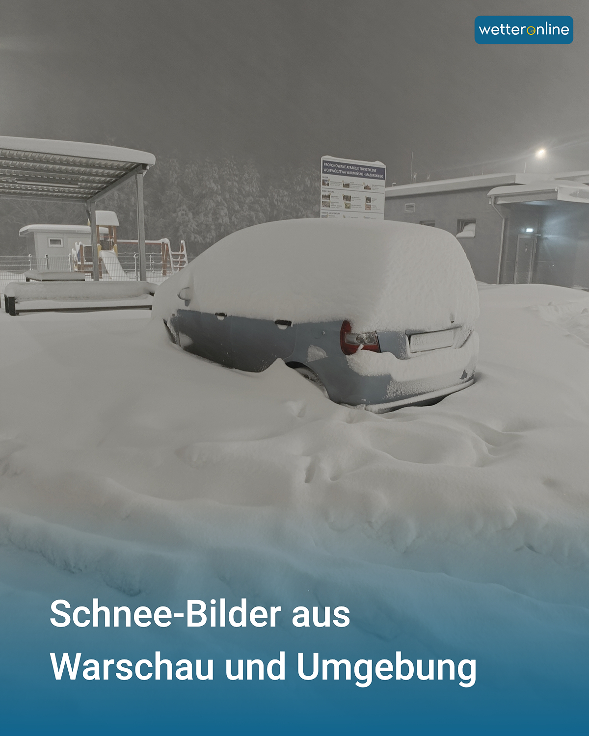 Komplett eingeschneites Auto auf einem Parkplatz bei Nacht. Dicker Neuschnee bedeckt Fahrzeug und Boden.