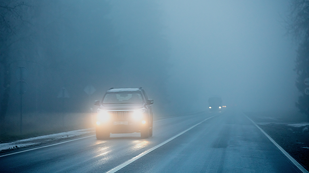 Imagen de un coche en un día de niebla densa.