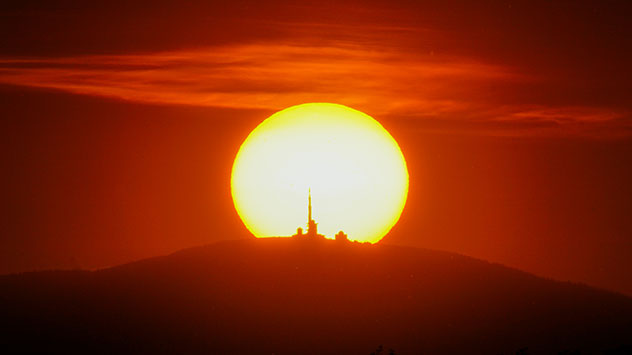 Die Sonne geht genau hinter dem Brockengipfel unter.
