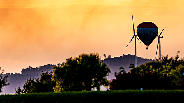 © Heinz-D. Fleck Heißluftballon vor Sonnenaufgang am gelblichen Himmel