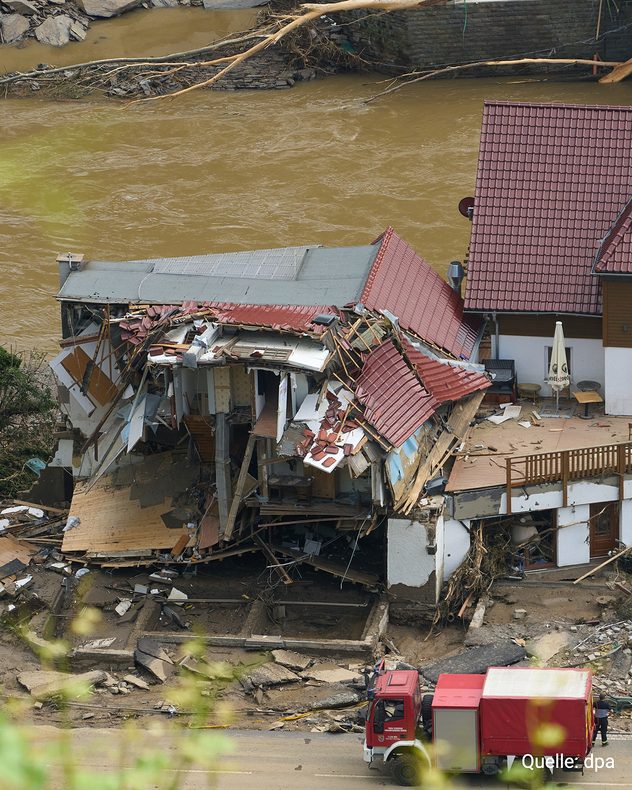 Teilweise eingestürztes Wohnhaus direkt an einem angeschwollenen Fluss nach der Flut.
