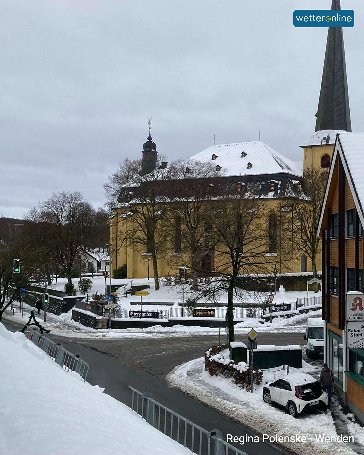 Verschneite Straße mit Kirche und Häusern im Ort Wenden.