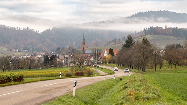 Eine Landschaft mit Nebel, Sonne und Wolken.