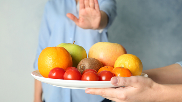 Kreuzallergie bei Haselpollen - Hand schiebt Obstschale weg